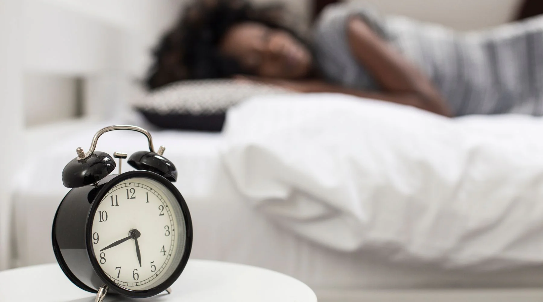 Alarm clock and bed represents deep restorative sleep